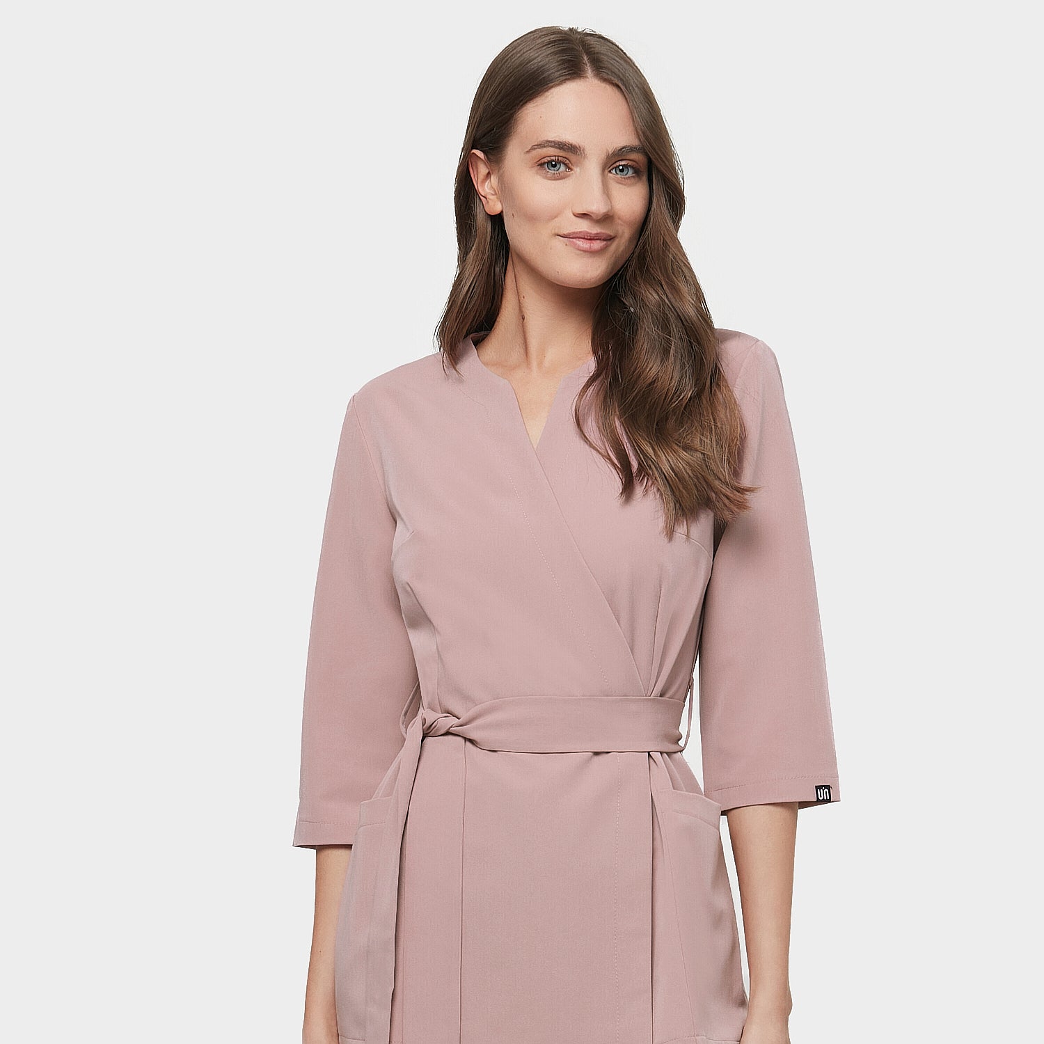 Detale fartuszka medycznego Sophia z długimi rękawami w kolorze dusty pink na kobiecie.