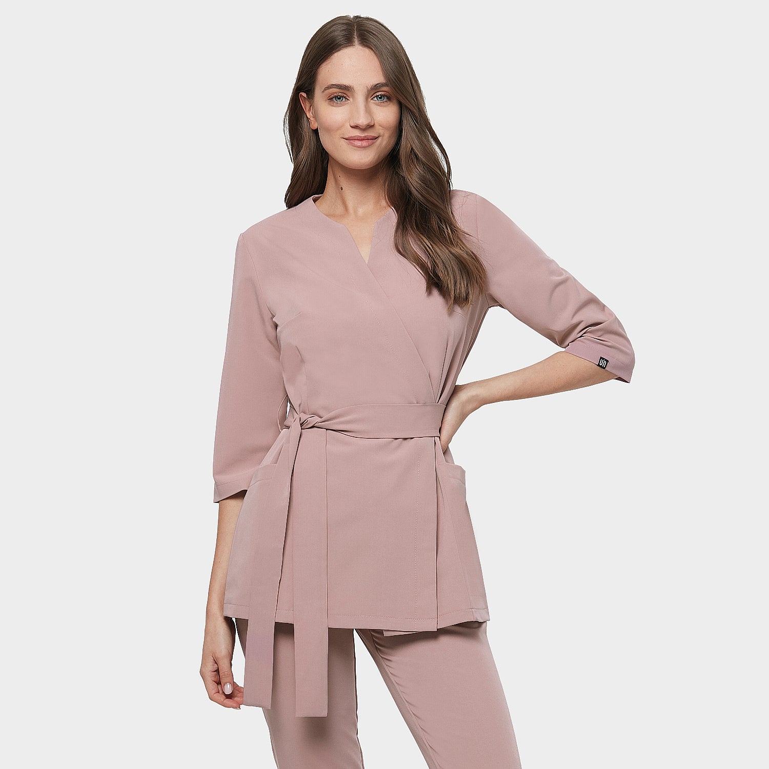Detale fartuszka medycznego Sophia z długimi rękawami w kolorze dusty pink na kobiecie.