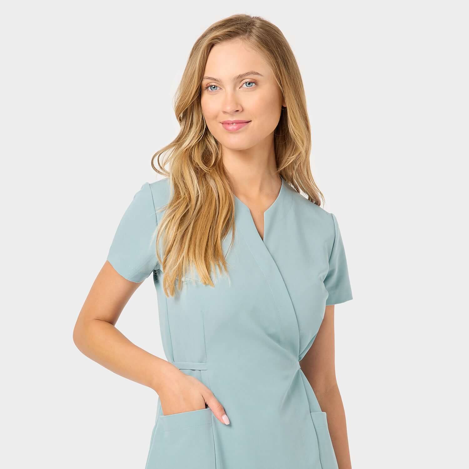 Sukienka medyczna KATE Dusty Blue - detale kieszeni: Zbliżenie na kieszenie sukienki medycznej w kolorze Dusty Blue, podkreślające funkcjonalność i praktyczność w codziennej pracy.