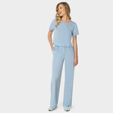 Bluza medyczna Gaja crop w kolorze BABY BLUE od Vena Uniformy.
Modelka stoi na jasnym tle w pastelowym komplecie medycznym: bluza z krótkim rękawem oraz szerokie spodnie, zestawione z niebieskimi sneakersami.