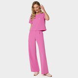 Bluza medyczna Gaja crop w kolorze Disco Pink od Vena Uniformy.
Modelka na jasnym tle w komplecie medycznym: bluza z krótkim rękawem oraz szerokie spodnie, zestawione z beżowymi sneakersami.