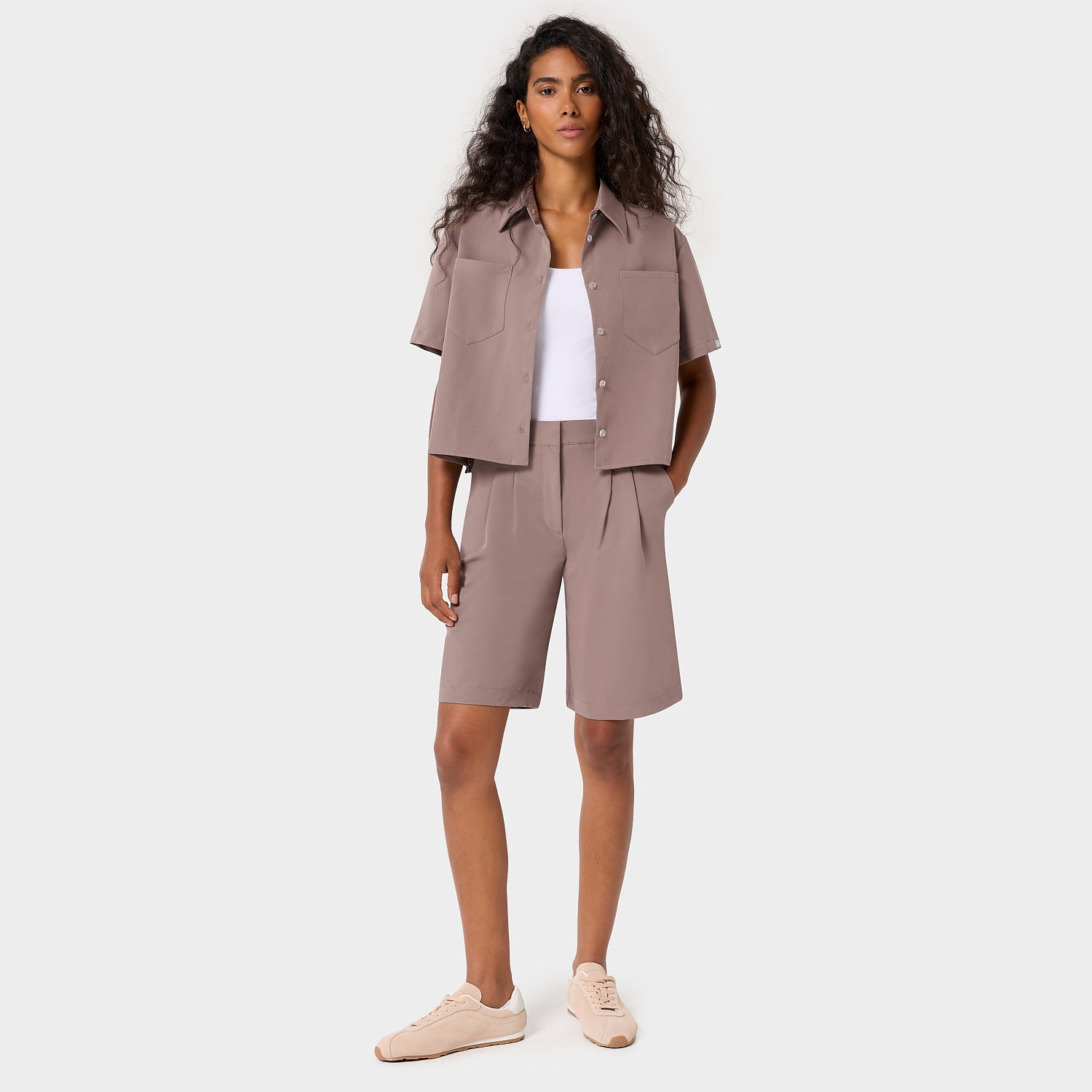 Kobieta w bluzie medycznej koszulowej Mia w kolorze Light Brown - brązowa rozpinana bluza scrubs z klasycznym kołnierzykiem, kobieca odzież medyczna Vena Uniformy