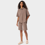Kobieta w bluzie medycznej koszulowej Alice w kolorze Mocha - brązowa oversize'owa bluza rozpinana na guziki z obniżoną linią rękawa, Vena Uniformy 