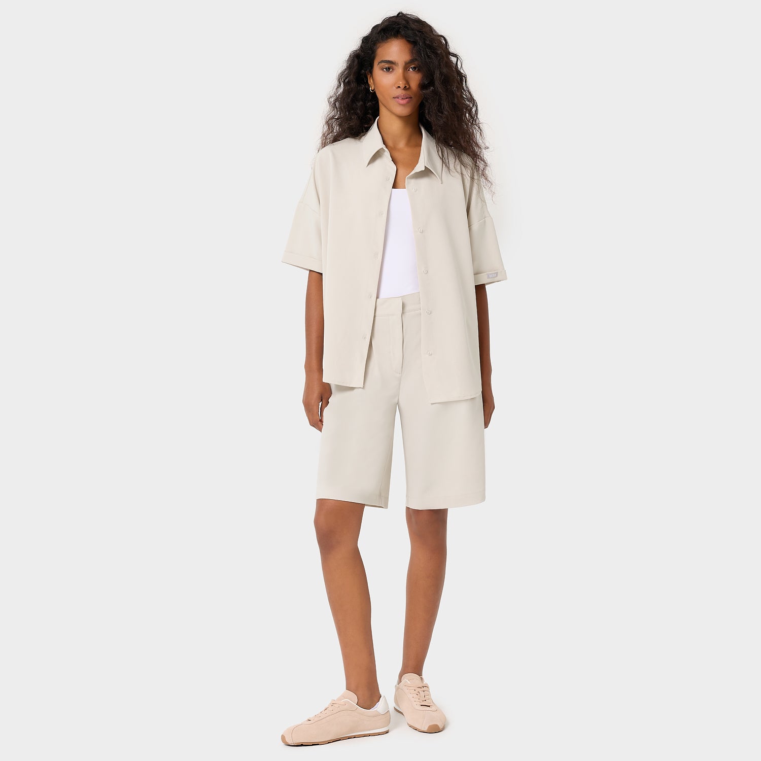 Modelka w oversize'owej bluzie medycznej Alice Nude - beżowa koszulowa bluza scrubs z klasycznym kołnierzykiem, damska odzież medyczna Vena Uniformy