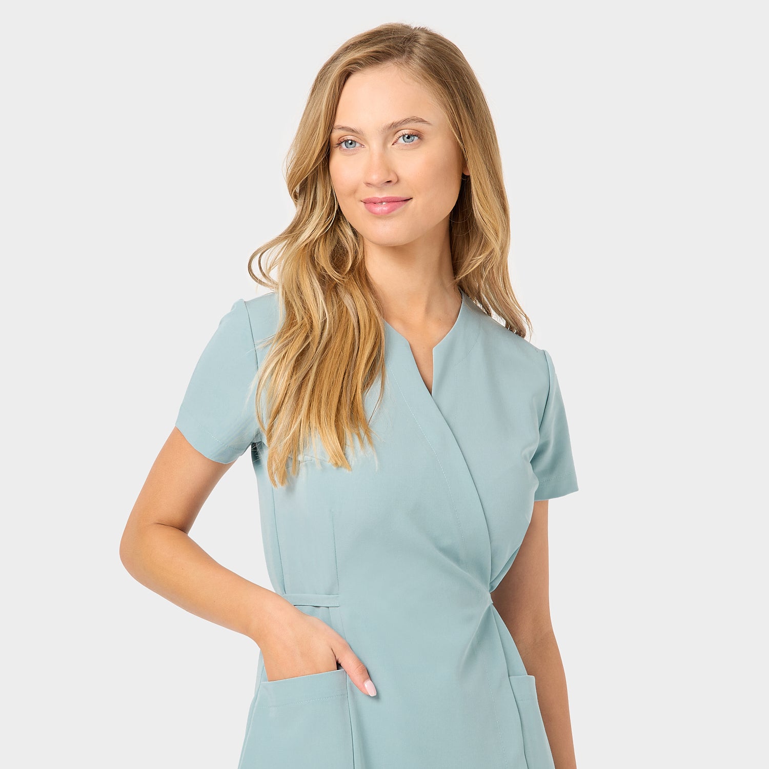 Sukienka medyczna KATE Dusty Blue - detale kieszeni: Zbliżenie na kieszenie sukienki medycznej w kolorze Dusty Blue, podkreślające funkcjonalność i praktyczność w codziennej pracy.